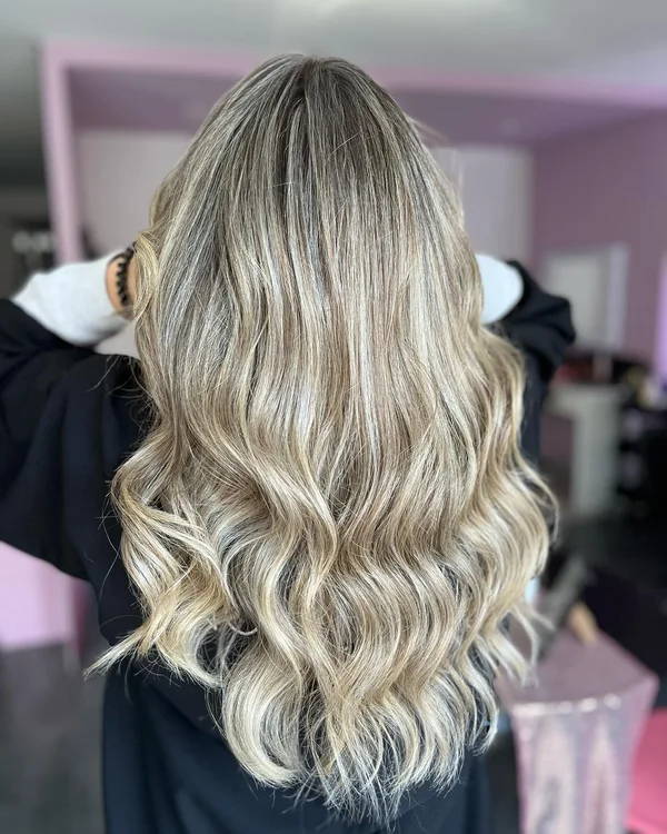 Melena rubia con ondas y matices de color realizados en Nuria Olías